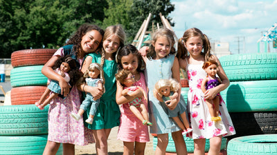 Grupo diverso de niñas jugando con muñecas