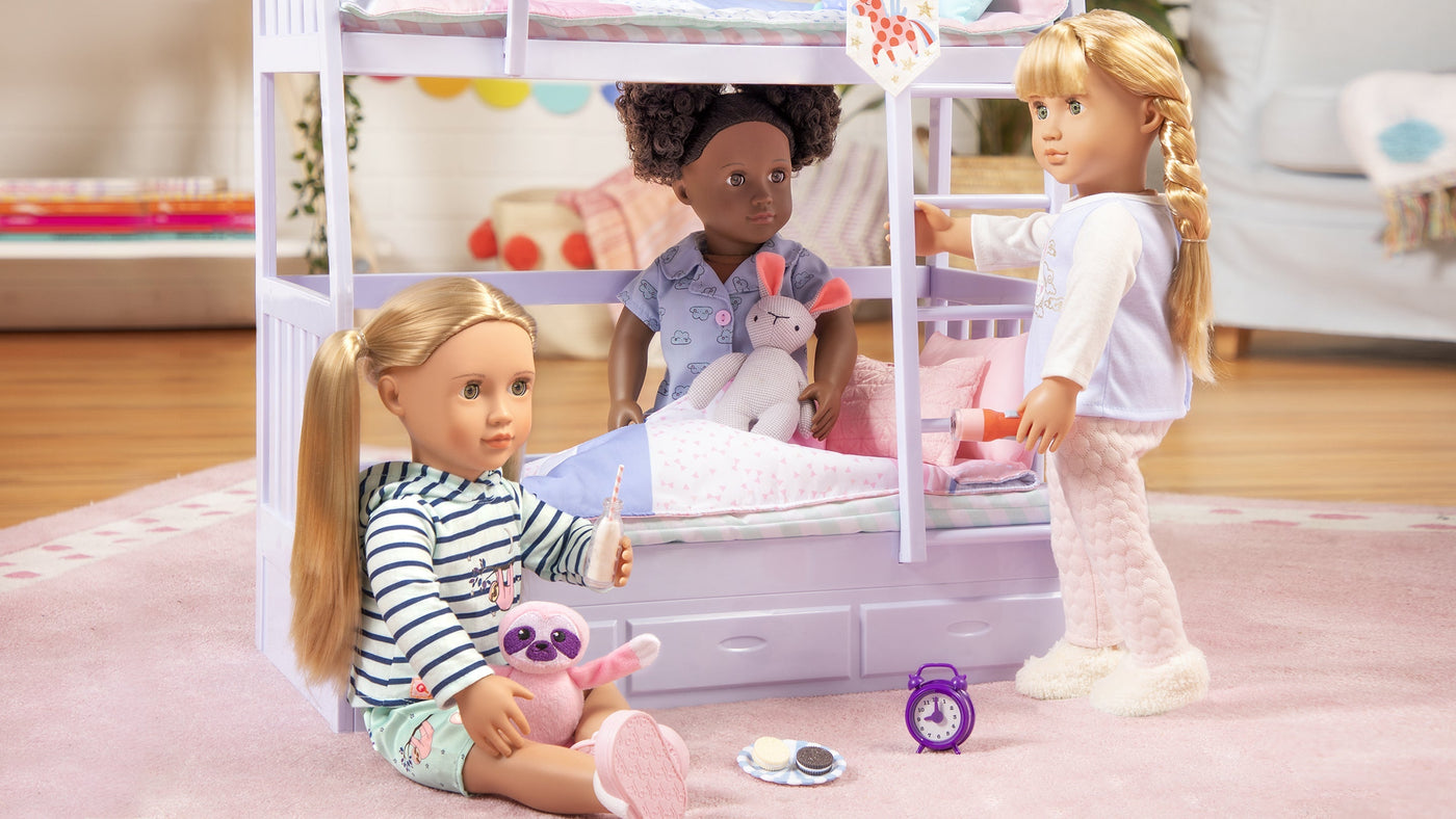 Tres muñecas jugando con un juego de camas literas lila